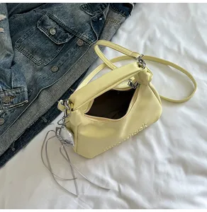 Détail du sac à bandoulière en cuir crème avec lettres gaufrées et charme de cœur