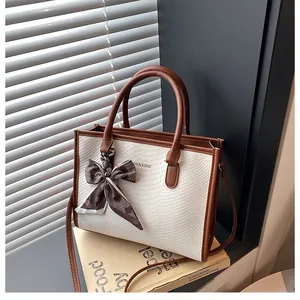 Détail du sac cabas bicolore avec texture serpent, poignée en foulard et bandoulière