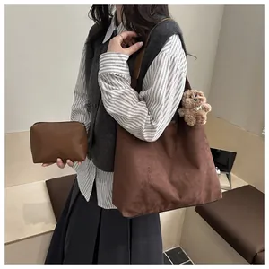 Detail of dark brown matte tote bag with matching pouch and plush bear charm decoration