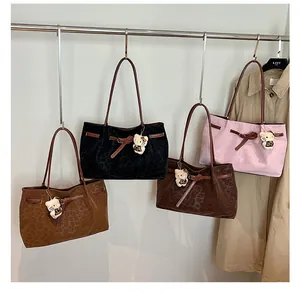 Dettaglio di quattro borse tote con stampa leopardata in vari colori e graziosi ciondoli