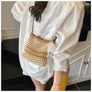 Détail du sac bandoulière tissé ajouré avec nœud en dentelle et accent perle