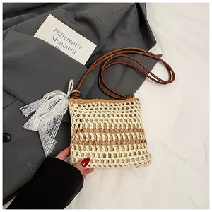 Détail du sac bandoulière tissé avec lanière en cuir et breloque en dentelle perlée