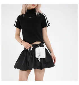 Détail de la mini pochette carrée blanche zippée sur un ensemble de sport noir femme