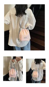 Dettaglio della borsa a secchiello in nylon rosa e grigio con tracolla a pois