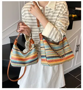 Detail of colorful striped woven tote bag with leather straps and metal chain accents