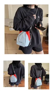 Dettaglio delle cuciture a contrasto e del logo su una borsa a secchiello in nylon
