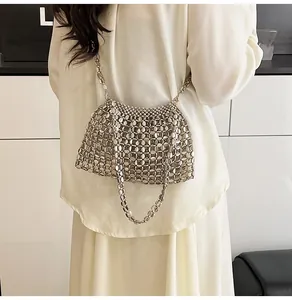 Détail du sac à bandoulière tressé en perles argentées sur mannequin, style épuré