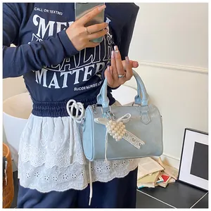Detail of light blue mini handbag with glossy wrinkled leather and pearl heart pendant