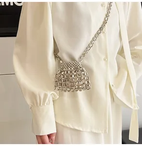 Détail du sac à bandoulière en perles argentées avec un design tissé ajouré et une chaîne