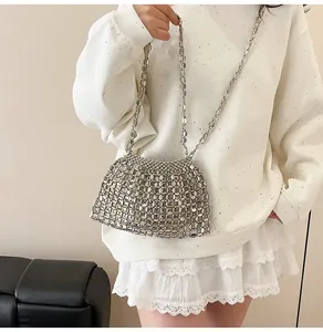 Gros plan sur un sac à bandoulière fait main en perles argentées au design ajouré