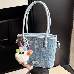 Sac seau patchwork en denim bleu clair avec pendentif en peluche et étiquette en cuir