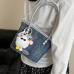 Sac seau en denim bleu avec anses argentées et breloques colorées en peluche