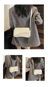Détail du sac selle blanc crème avec rabat ondulé et boucle en métal doré chic