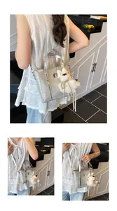 Detailed macro view of silver crocodile pattern bag with plush puppy and metal tassel