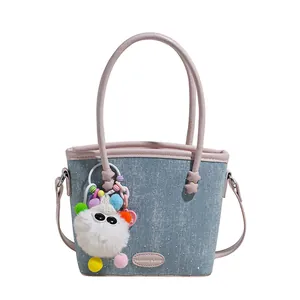 Sac à main en denim bleu clair avec garniture en cuir rose et porte-clé peluche blanc