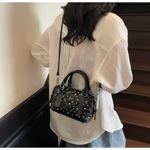Dettaglio di una borsa trapuntata nera con strass argentati in un contesto street style