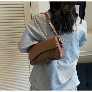 Détail d'un sac besace marron porté par un mannequin pour montrer la taille et l'ajustement