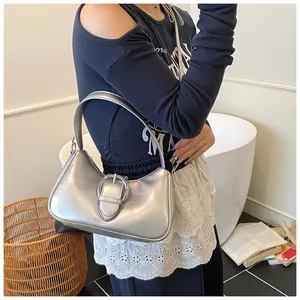 Borsa hobo argento metallizzato con grande fibbia mostrata in un ambiente lifestyle
