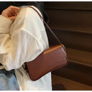Détail du sac besace vintage marron foncé en cuir lisse avec des finitions dorées chic