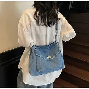 Vue de dos d'une femme portant un sac cabas en denim délavé bleu avec bandoulière