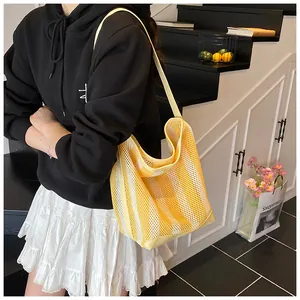 Primer plano del bolso tote de malla a rayas amarillas y blancas para vacaciones de verano.