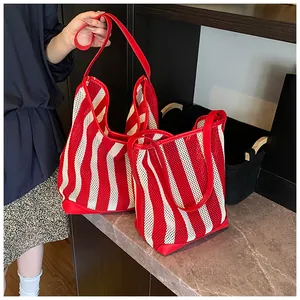 Bolsos tote de malla calada a rayas rojas y blancas para un estilo informal de vacaciones.