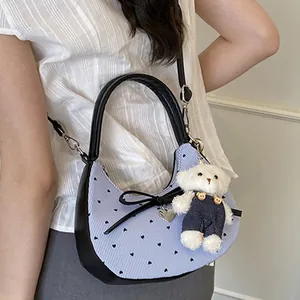Sac croissant chic à rayures bleues avec nœud noir et breloque ours en peluche