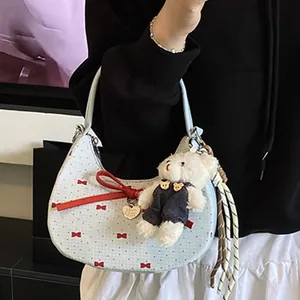 Sac croissant bleu à pois avec nœuds rouges et pendentif ours porté par mannequin