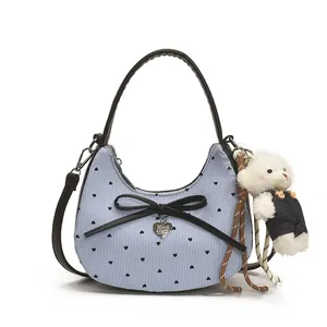 Sac à main en croissant rayé bleu et blanc avec nœud noir et breloque ours en peluche