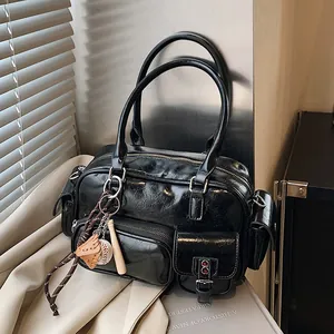 Glossy black bowling handbag with multi-pocket design and baseball charm accessories