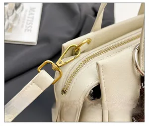 Detailed close-up of premium vintage gold hardware and stitching on beige handbag