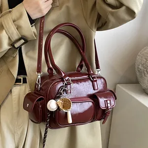 Deep red Boston style bowling bag with glossy finish and baseball charm accessory