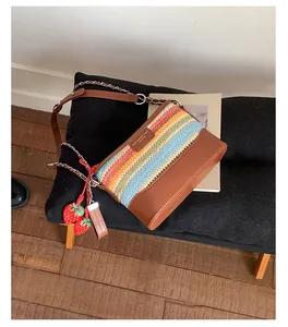 Detail der bunten gewebten Schultertasche mit Lederboden und süßen Erdbeer-Anhängern