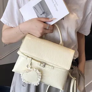 Minimalist beige textured women's tote bag with heart lace charm and detachable strap