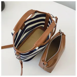 Detail of blue striped woven bucket bag set with brown inner pouch and branded interior