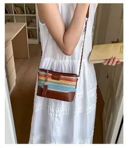 Detail der bunten geflochtenen Beuteltasche mit Lederbesatz und Kettenriemen am Modell