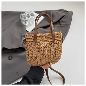 Détail de la texture en coton tissé avec poignées en cuir marron et fermoir à bouton argenté