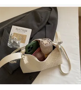 Vue détaillée du compartiment intérieur spacieux de ce sac à bandoulière tissé crème