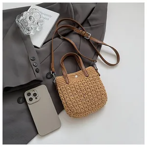 Détail du sac à main en paille tressée avec texture crochetée et bandoulière en cuir réglable