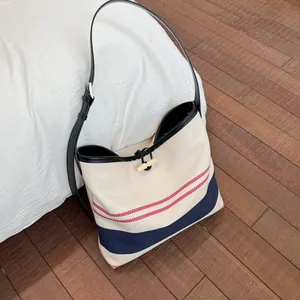 Large capacity striped canvas tote bag featuring wooden toggle closure and adjustable strap