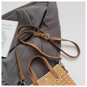 Détail du sac bandoulière en paille tressée avec poignée en PU marron et bandoulière