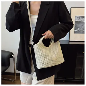 Detail of cream white mesh tote bag with hollow grid texture and adjustable shoulder strap