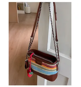 Detailansicht der bunten geflochtenen Beuteltasche mit Lederbesatz und Erdbeeranhänger