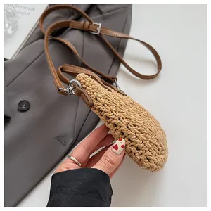 Détail du sac à bandoulière tissé avec sangle en cuir marron réglable et boucles métal