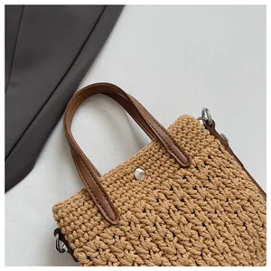 Détail du tissage en coton avec poignées en cuir marron et fermoirs métalliques argentés