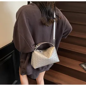 Détail d'un sac hobo tressé argenté montrant la texture et la fine bandoulière
