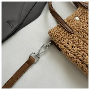Détail d'un sac en coton tissé avec fermoirs argentés et bandoulière en cuir souple