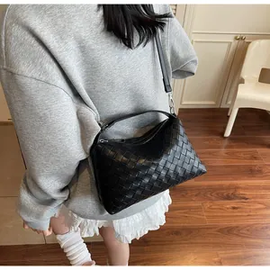 Détail du sac à bandoulière noir tissé classique avec sangle réglable et boucle en métal argenté