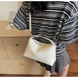 Vue détaillée de la texture en cuir tissé blanc sur un sac bandoulière chic