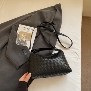 Détail du sac à main en cuir tressé noir montrant la texture intrecciato et la poignée